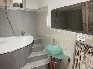 a bathroom with a sink and a bath tub at Apartments Let Me In in Pörtschach am Wörthersee +66 photos