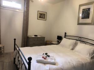 a bedroom with a bed with white sheets and a window at Boutique Appartement 2 Chambres dans le Vieux Cahors in Cahors