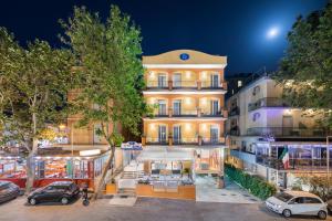 un edificio con coches estacionados frente a él en Viva Beach Hotel en Rímini