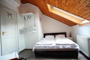 a bedroom with a bed with a wooden ceiling at Villa Bea Panzió in Zamárdi