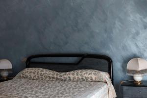 a bedroom with a bed with a blue wall at Guesthouse Mare&Monti Castelforte in Castelforte