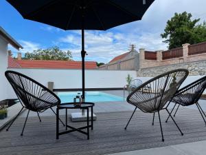 2 Stühle und ein Tisch mit Sonnenschirm auf der Terrasse in der Unterkunft Summerhouse penzion Bavory in Bavory