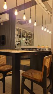 uma cozinha com uma mesa e duas cadeiras e luzes em Link Araranguá em Araranguá
