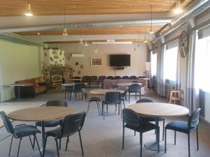 a room with tables and chairs and a tv at Ilmatsalu Motell in Ilmatsalu