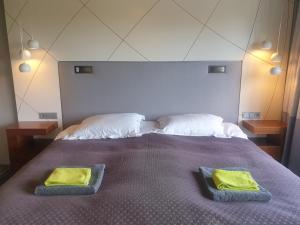 1 dormitorio con 1 cama y 2 toallas verdes en Ilmatsalu Motell, en Ilmatsalu