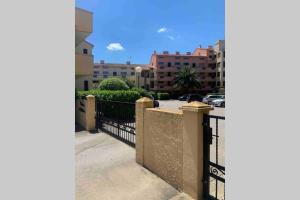 a view of a fence and a street with buildings at Appartement Argelès-sur-Mer avec piscine à 500m de la mer in Argelès-sur-Mer