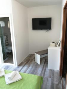 Pokój z telewizorem, ławką i lustrem w obiekcie Apartments Vucetic w Hvarze