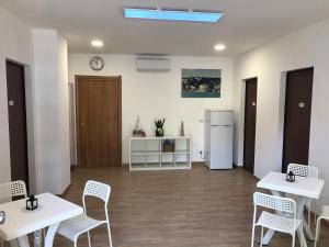 a room with tables and chairs and a refrigerator at West Ponente in Francavilla al Mare