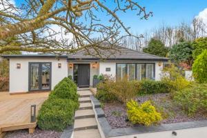 a home with a wooden porch and a house at Harrogate boutique lodge with heated pool and hot tub in Staveley