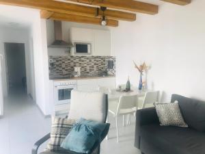a kitchen and living room with a couch and a table at Olas de Lobos in Corralejo
