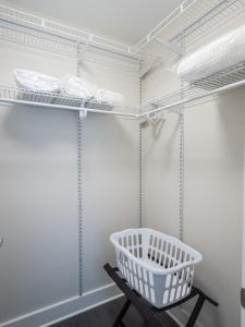 - une buanderie avec des murs blancs et des étagères en métal dans l'établissement Global Luxury Suites at Bethesda Metro, à Bethesda