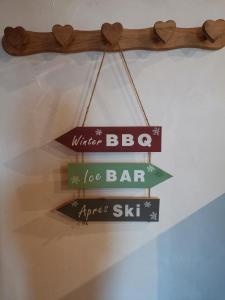 a wooden sign hanging from a ceiling with four signs at Residence le Cairn in Le Monêtier-les-Bains