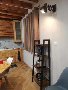a room with a table and a kitchen with wooden floors at Residence le Cairn in Le Monêtier-les-Bains
