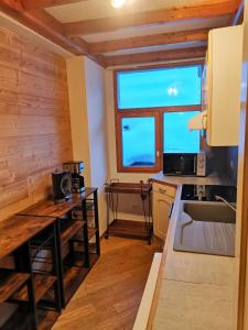 cocina con paredes de madera y ventana grande en Residence le Cairn en Le Monêtier-les-Bains