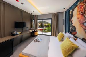 a hotel room with a bed and a large window at Neva Kaş in Kaş