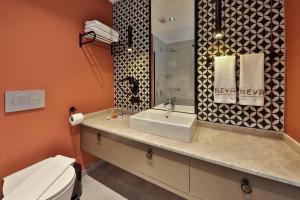 a bathroom with a sink and a toilet and a mirror at Neva Kaş in Kaş