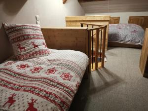 a bedroom with a bed and a pillow and a crib at Residence le Cairn in Le Monêtier-les-Bains