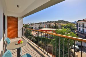 a balcony with a table and chairs and a view at Neva Kaş in Kaş