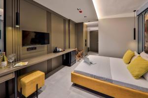 a bedroom with a bed and a desk with a laptop at Neva Kaş in Kaş