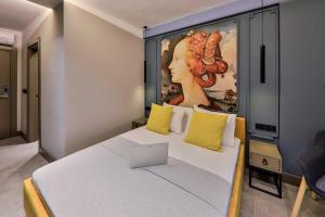 a bedroom with a bed with a painting on the wall at Neva Kaş in Kaş