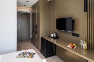 a hotel room with a desk with a tv and fruit on it at Neva Kaş in Kaş