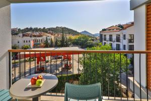 a balcony with a table and fruit on a tray at Neva Kaş in Kaş
