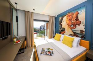 a bedroom with a bed with a painting on the wall at Neva Kaş in Kaş