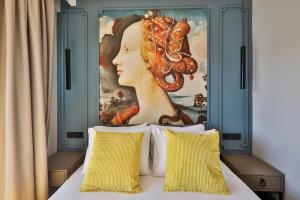 a painting above a bed with two pillows at Neva Kaş in Kaş