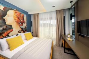 a hotel room with a bed with a painting on the wall at Neva Kaş in Kaş