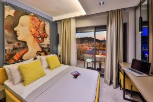 a bedroom with a bed and a desk with a laptop at Neva Kaş in Kaş