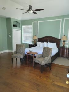 a bedroom with a bed with two chairs and a table at The Inn at 161 in Sutter Creek