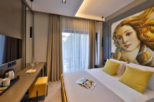 a hotel room with a bed with a painting of a woman at Neva Kaş in Kaş