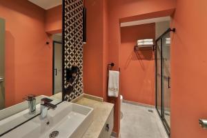 a bathroom with orange walls and a white sink at Neva Kaş in Kaş