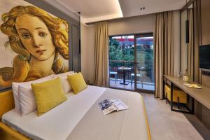 a bedroom with a large painting of a woman at Neva Kaş in Kaş