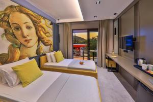 a bedroom with a large painting of a woman at Neva Kaş in Kaş
