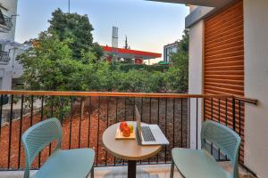 a balcony with a table with a laptop and chairs at Neva Kaş in Kaş