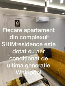 a living room with a couch and a sign on a wall at SHIMresidence LUXURY in Rădăuţi