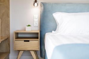 um quarto com uma cama e uma mesa de cabeceira com uma cama branca em Onore Luxury Suites em Kato Korakiana