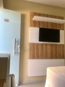 a bedroom with a bed and a tv on a wall at Pousada Life in Ubajara