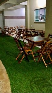 a group of wooden tables and chairs on grass at Pousada Life in Ubajara