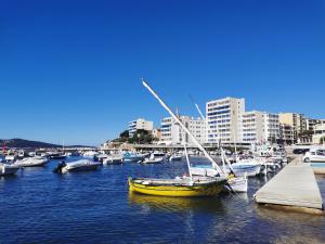 a yellow boat is docked in a harbor with other boats at Studio avec vue in Toulon