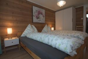 a bedroom with a bed with a wooden wall at Haus Wiedersehen, Weissmies (3-Zi) in Saas-Grund
