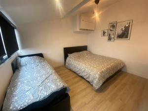 duas camas num pequeno quarto com em Loft 3 chambres Bastille, Marais, Père Lachaise em Paris