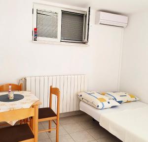 a room with two beds and a table and a window at Guesthouse Pejo in Poreč
