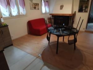uma sala de estar com uma cadeira vermelha e uma mesa em Le petoumier la bolline em Valdeblore