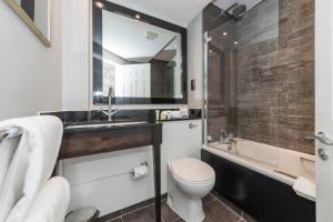 a bathroom with a toilet and a sink and a tub at Warbrook House Heritage Hotel in Hook