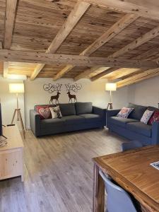 ein Wohnzimmer mit 2 Sofas und einem Tisch in der Unterkunft Chez Tina in Asiago