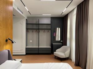 a bedroom with a bed and a chair at Hotel La Favorita in Tirana