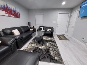 a living room with a black leather couch and a glass table at Nice house between two beaches. in Gulf Breeze