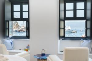 a living room with windows overlooking a marina at MyCrown Suite, Luxurious apartment with sea view located at the port of Hydra in Hydra
